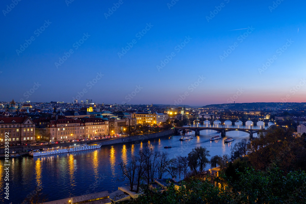 Fototapeta premium Panorama of the old part of Prague from the Letna park at dusk. Beautiful view on the bridges over the river Vltava at sunset. Old Town architecture, Czech Republic.