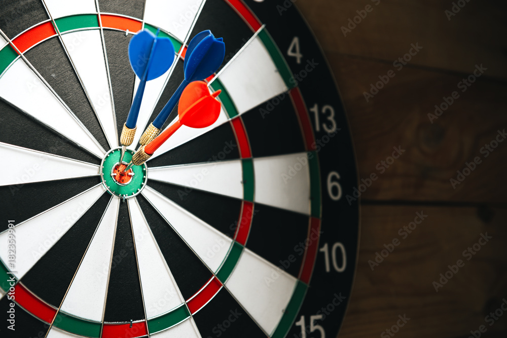 Dart arrow hitting in the target center of dartboard Dart arrow hitting in the target center of dartboard