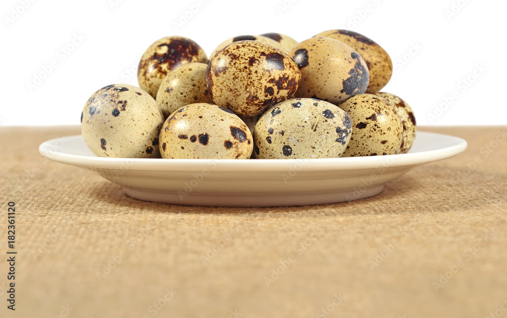 Quail eggs in a white bowl in a sacking Quail eggs in a white bowl in a sacking