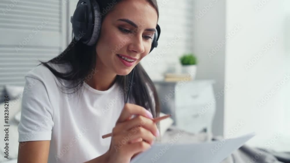 Creative process. Pleasant beautiful nice woman sitting in bed and listening to music while composing a song Creative process. Pleasant beautiful nice woman sitting in bed and listening to music while composing a song
