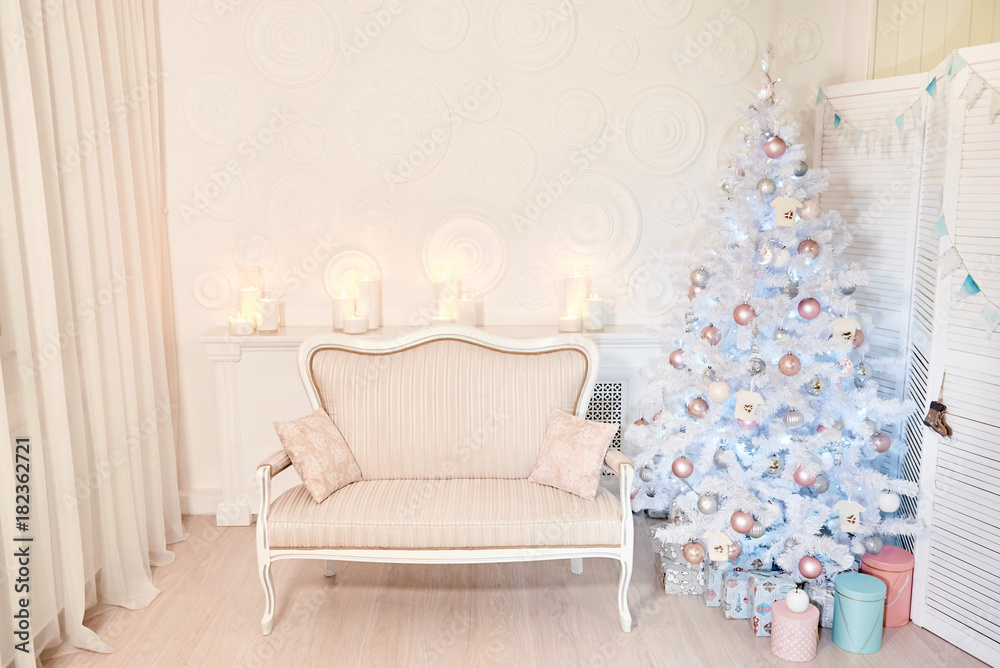 Stylish Christmas interior decorated in white colors. New Year interior room with presents and New year tree. Comfort home.