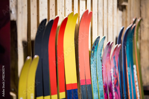 Ski shop sale. Rows of  colourful skis on wooden wall.  photo