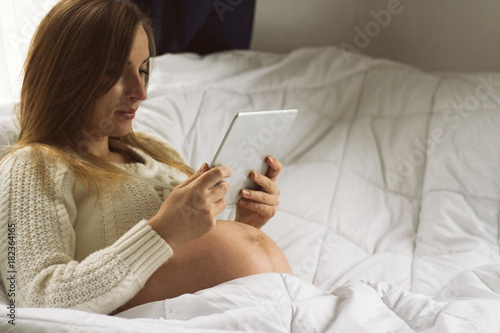 Young pregnant woman with tablet