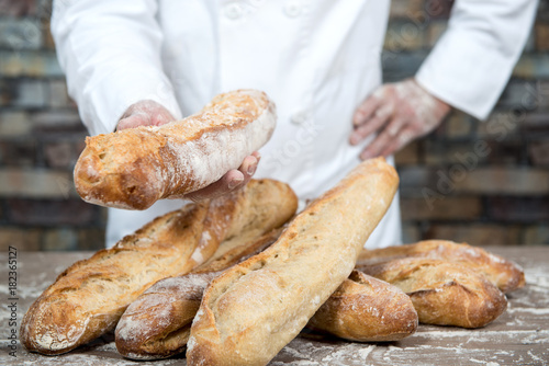 baker with traditional bread french baguettes