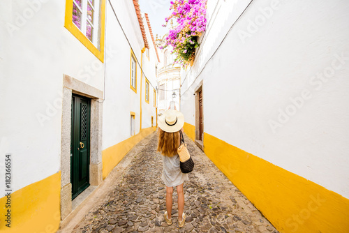 Young woman traveling on the street in the old town of Evora in Portugal