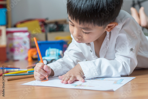 kid boy drawing with color pencils,Hand of asian child draw and paint with crayon in vintage color tone