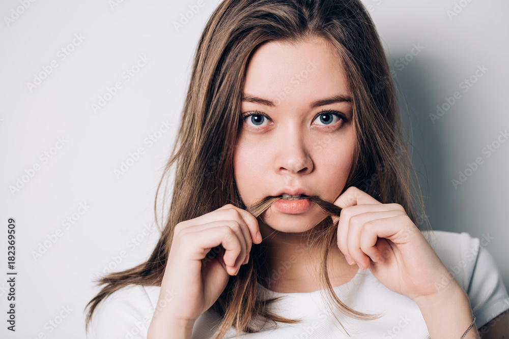 Close up indoor fashion lifestyle portrait of cool pretty young brunette girl, making crazy funny grimace, Bites hair Close up indoor fashion lifestyle portrait of cool pretty young brunette girl, making crazy funny grimace, Bites hair