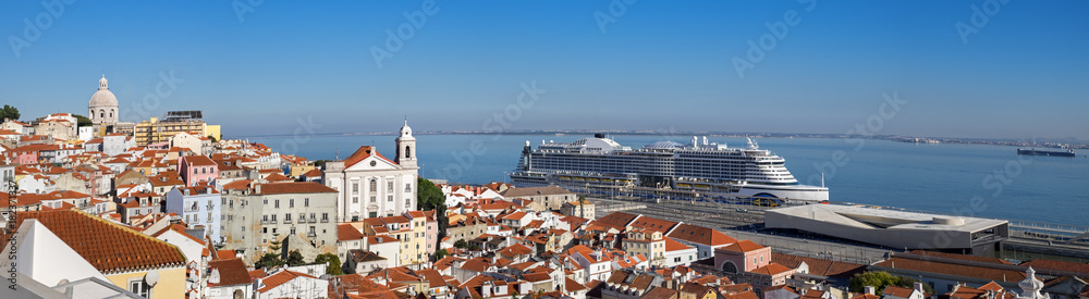 Very large panoramic view on Sao Vicente de Fora church, red roofs on Lisbon centre and big cruise liner ship on Tagus River. Portugal