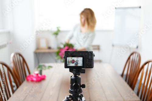 Defocused photo of woman blogger recording on camera master