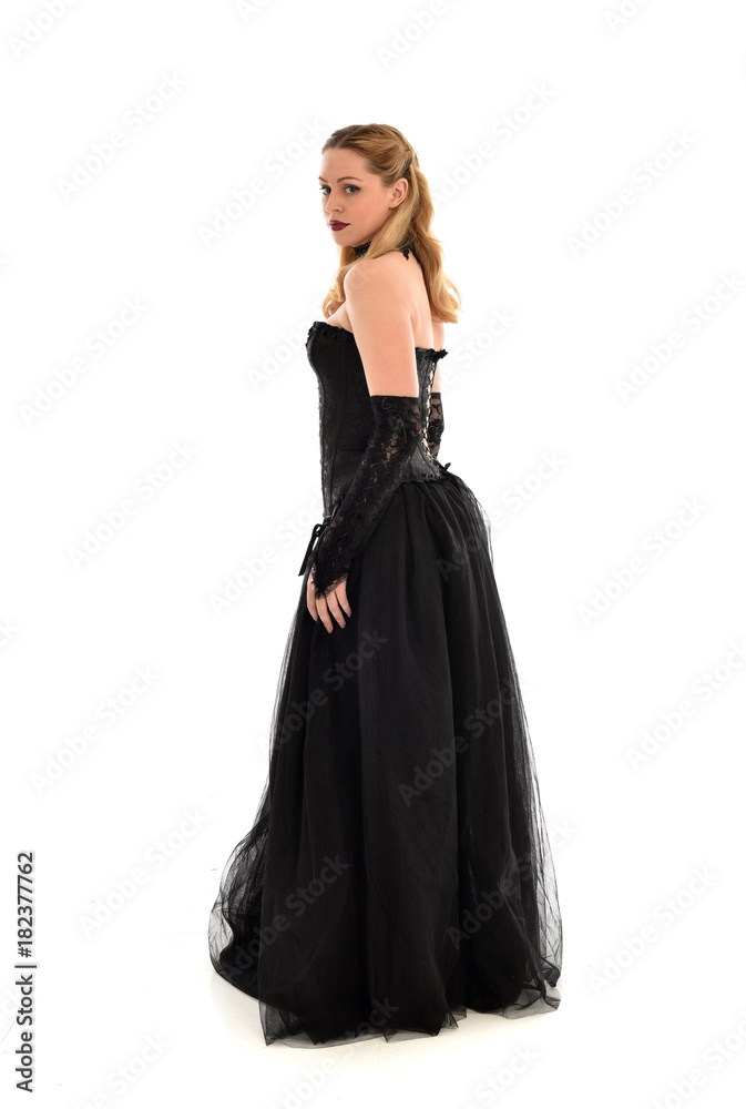 full length portrait of a blonde girl wearing black gothic gown. standing pose, isolated on white background. full length portrait of a blonde girl wearing black gothic gown. standing pose, isolated on white background.