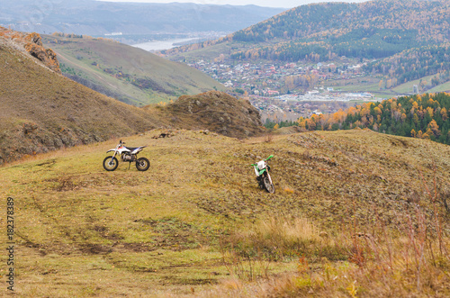 Two cross-country motorcycles in the mountains in autumn, free space for text