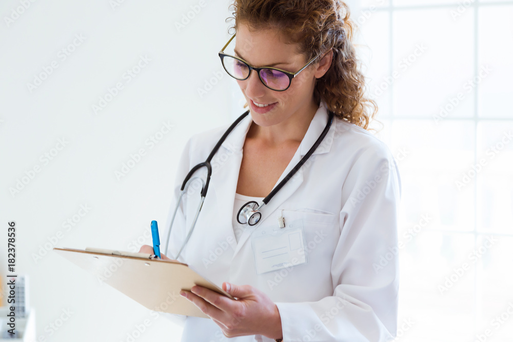 Confident female doctor writing information of her patient in the office. Confident female doctor writing information of her patient in the office.