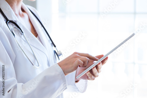 Female doctor using her digital tablet in the office.