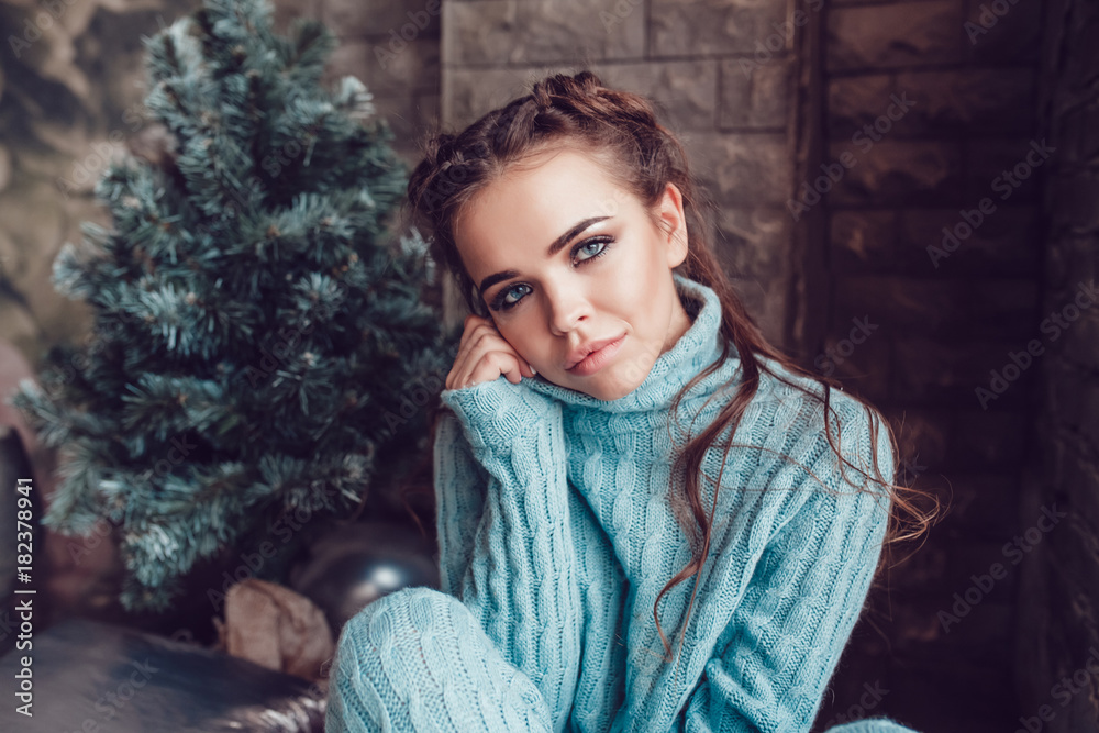 Portrait of a beautiful woman near a Christmas tree. New Year.