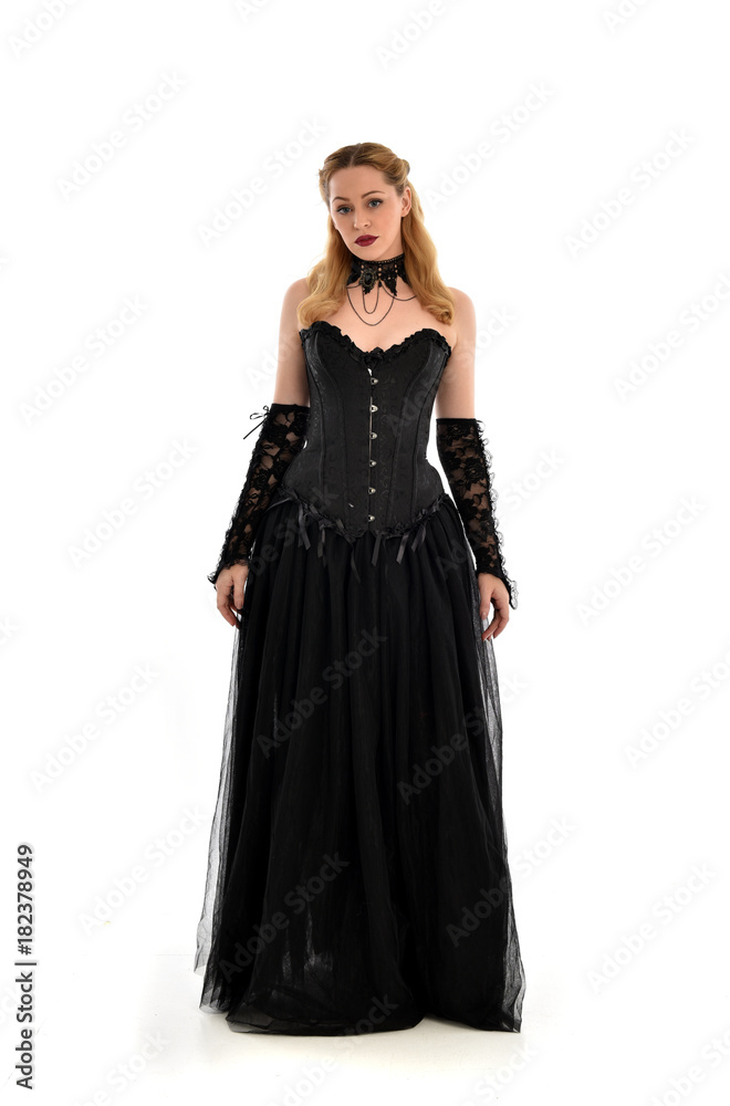 full length portrait of a blonde girl wearing black gothic gown. standing pose, isolated on white background. full length portrait of a blonde girl wearing black gothic gown. standing pose, isolated on white background.