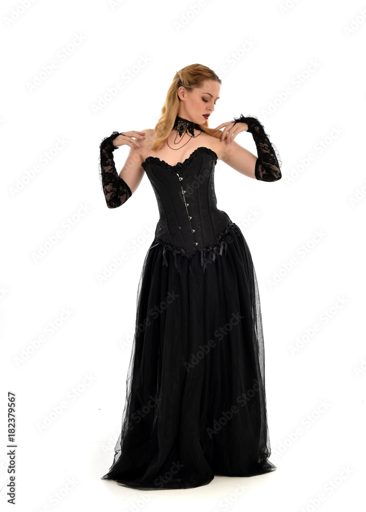 full length portrait of a blonde girl wearing black gothic gown. standing pose, isolated on white background. full length portrait of a blonde girl wearing black gothic gown. standing pose, isolated on white background.