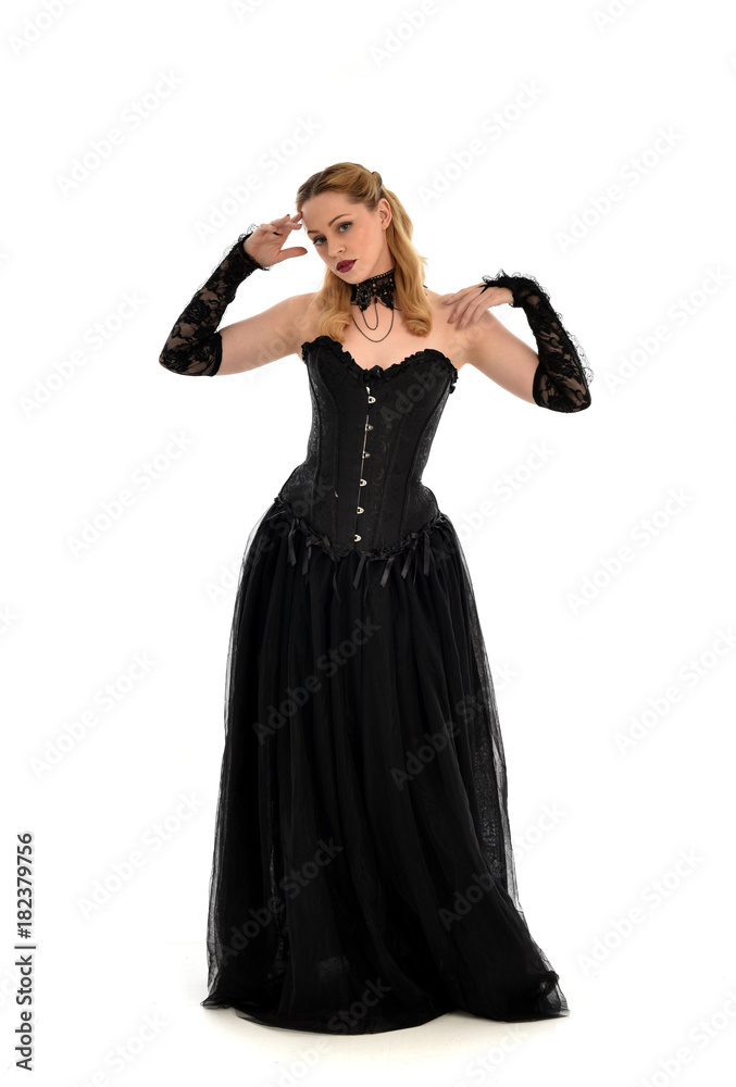 full length portrait of a blonde girl wearing black gothic gown. standing pose, isolated on white background. full length portrait of a blonde girl wearing black gothic gown. standing pose, isolated on white background.