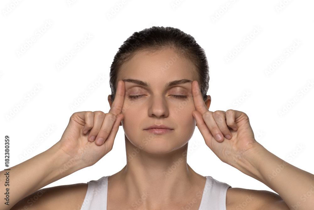Massage, yoga, gymnastics or rejuvenating exercises for the face makes the girl own hands on a white background Massage, yoga, gymnastics or rejuvenating exercises for the face makes the girl own hands on a white background