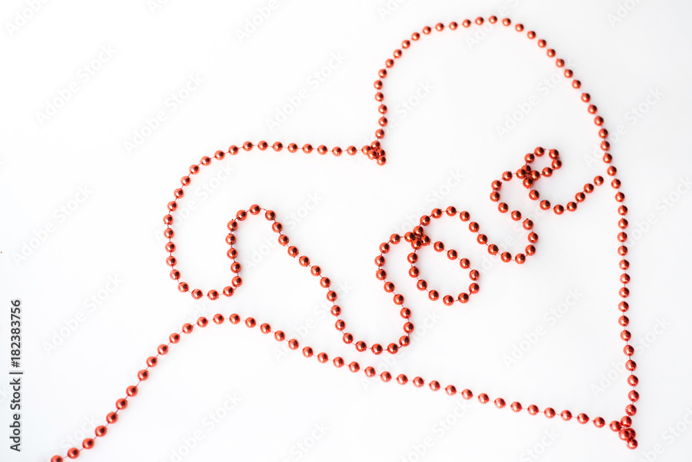 The word LOVE and symbol heart- declaration of written with red beads isolated on white background The word LOVE and symbol heart- declaration of written with red beads isolated on white background