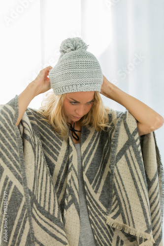 beautiful woman trying new wolly hat at home