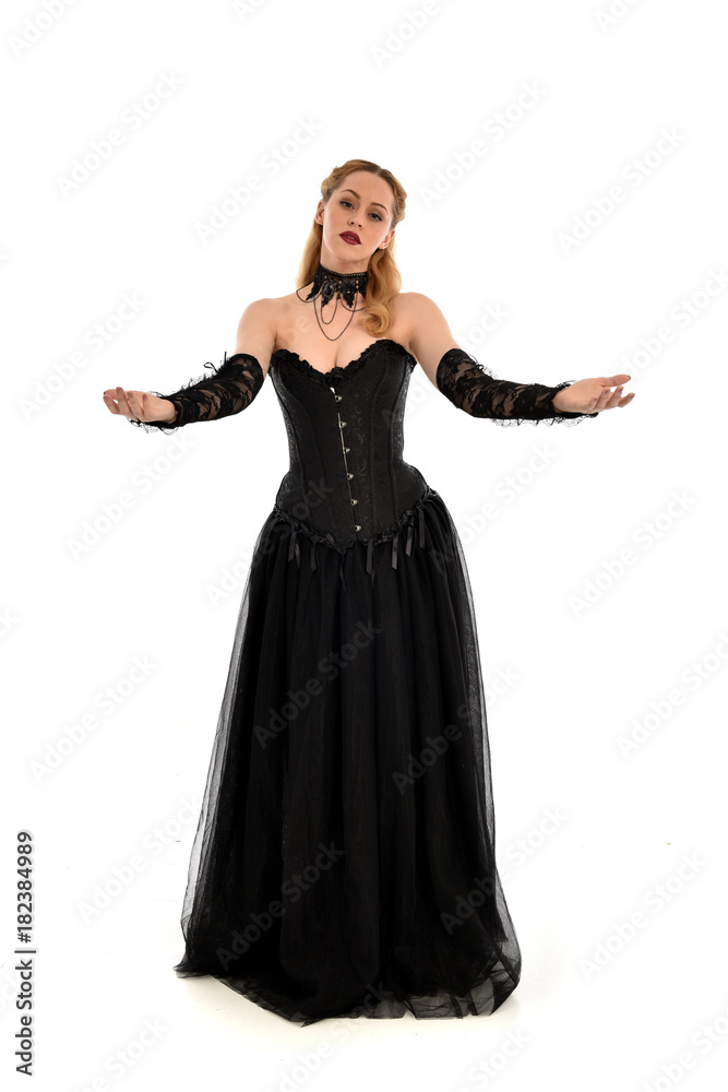 full length portrait of a blonde girl wearing black gothic gown. standing pose, isolated on white background. full length portrait of a blonde girl wearing black gothic gown. standing pose, isolated on white background.