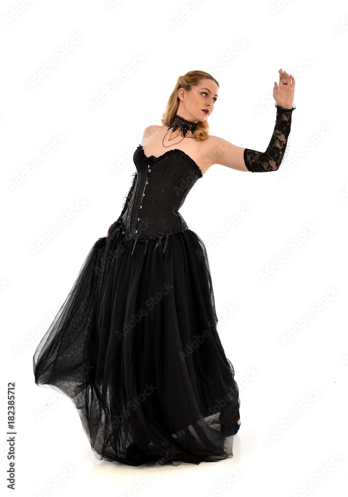full length portrait of a blonde girl wearing black gothic gown. standing pose, isolated on white background. full length portrait of a blonde girl wearing black gothic gown. standing pose, isolated on white background.