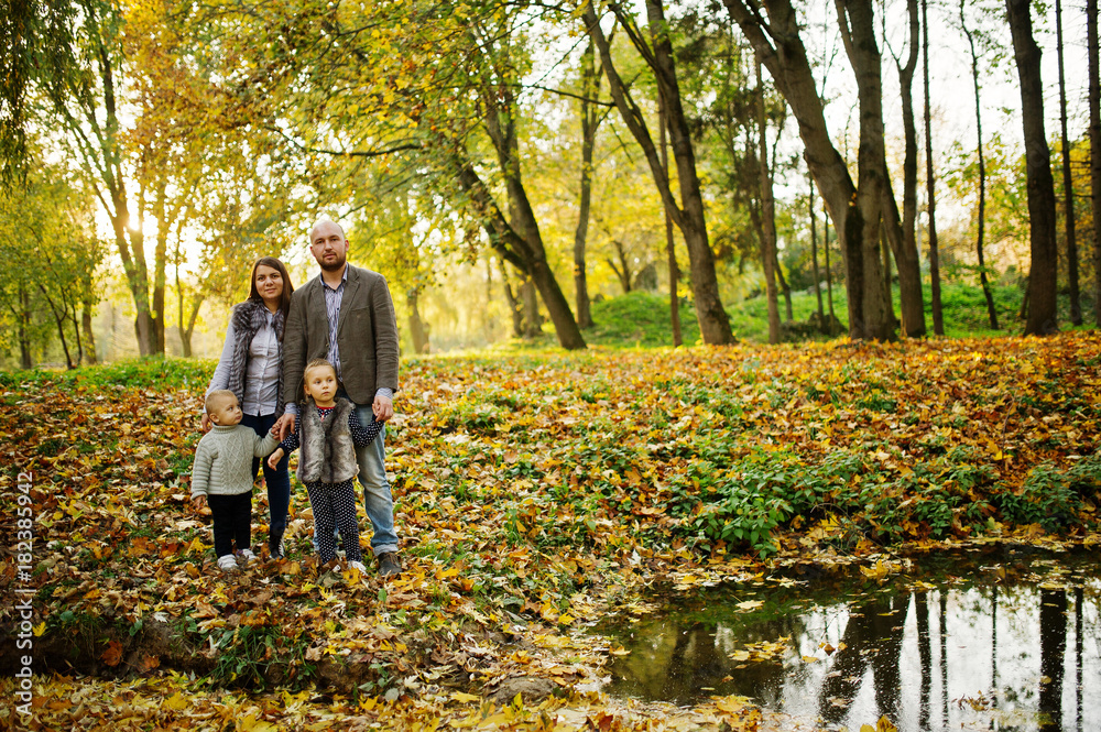 Happy caucasian family of mom dad and little girl with boy at majestic autumn fall forest. Happy caucasian family of mom dad and little girl with boy at majestic autumn fall forest.