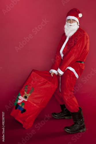 Santa Claus is carrying heavy presents