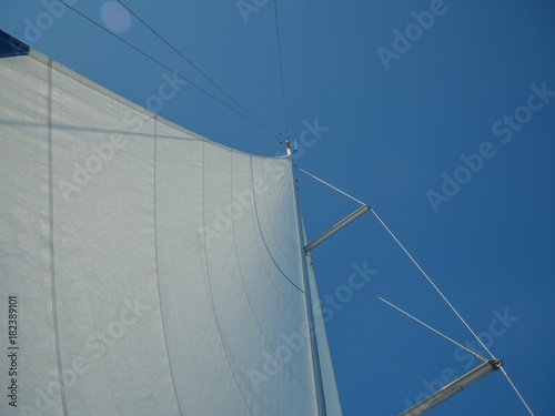 Mast with open sails and wind indicator on top.