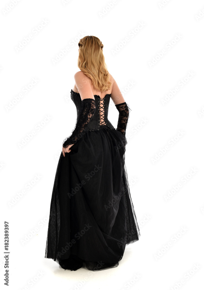 full length portrait of a blonde girl wearing black gothic gown. standing pose, isolated on white background. full length portrait of a blonde girl wearing black gothic gown. standing pose, isolated on white background.