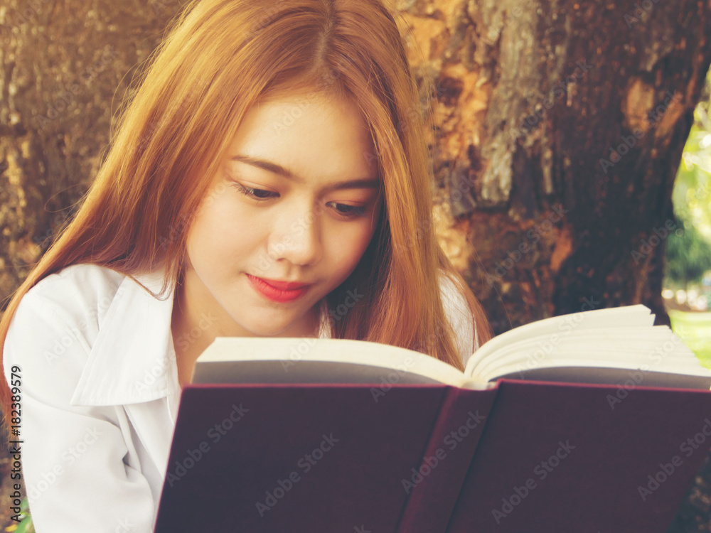 Close up face of young woman reading book at the park. Close up face of young woman reading book at the park.