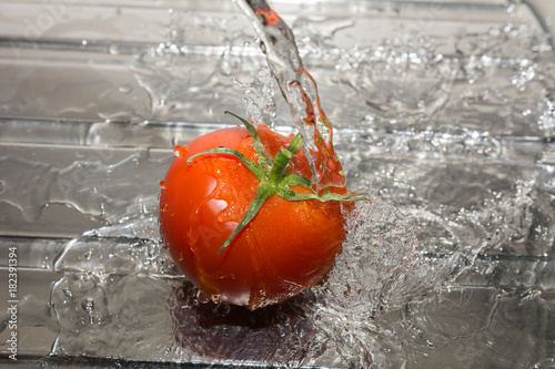 Wasser über die Tomate giessen