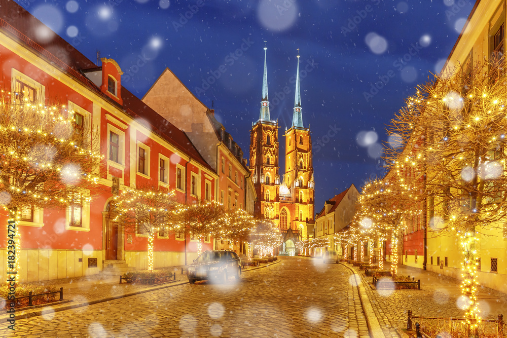 Fototapeta premium Cathedral of St. John at Cathedral Island or Ostrow Tumski at snowy christmas night in Wroclaw, Poland