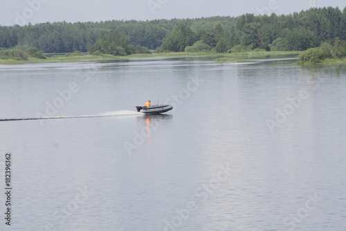 manages gray inflatable rubber boat with an outboard motor