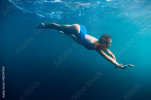 Young woman in bikini swimming in ocean