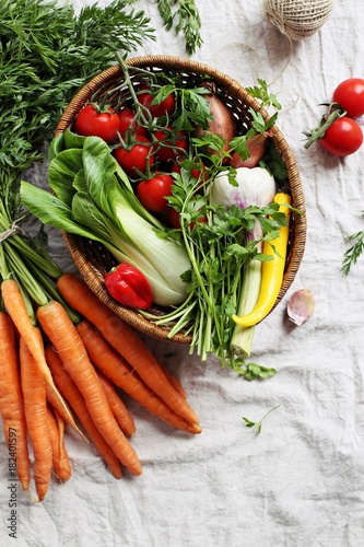 Vegetables and herbs. Fresh seasonal vegetables and herbs in the vintage basket. Overhead view