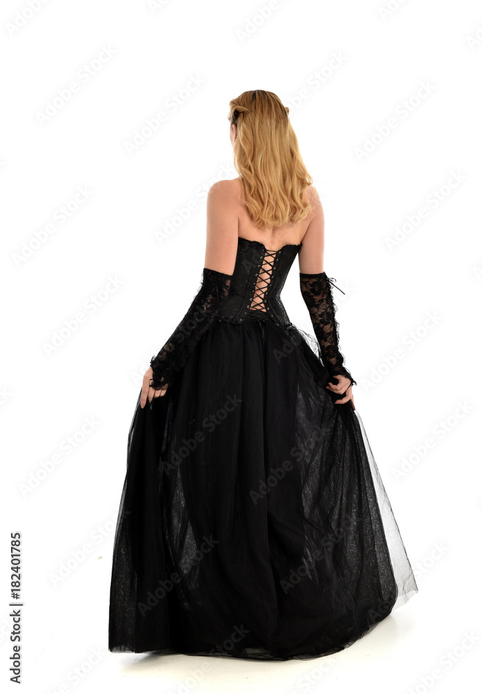 full length portrait of a blonde girl wearing black gothic gown. standing pose, isolated on white background. full length portrait of a blonde girl wearing black gothic gown. standing pose, isolated on white background.
