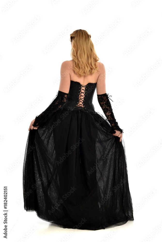 full length portrait of a blonde girl wearing black gothic gown. standing pose, isolated on white background. full length portrait of a blonde girl wearing black gothic gown. standing pose, isolated on white background.