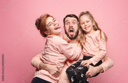 Happy young family with one little daughter posing together photo