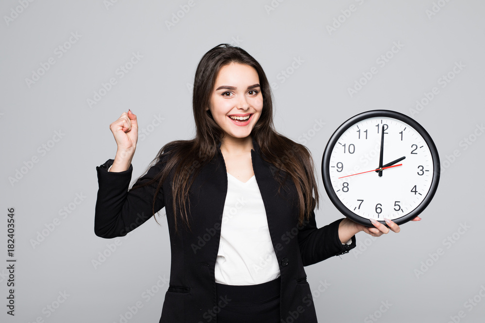 Happu excited Business woman in suit which holding clock in hands Isolated gray background