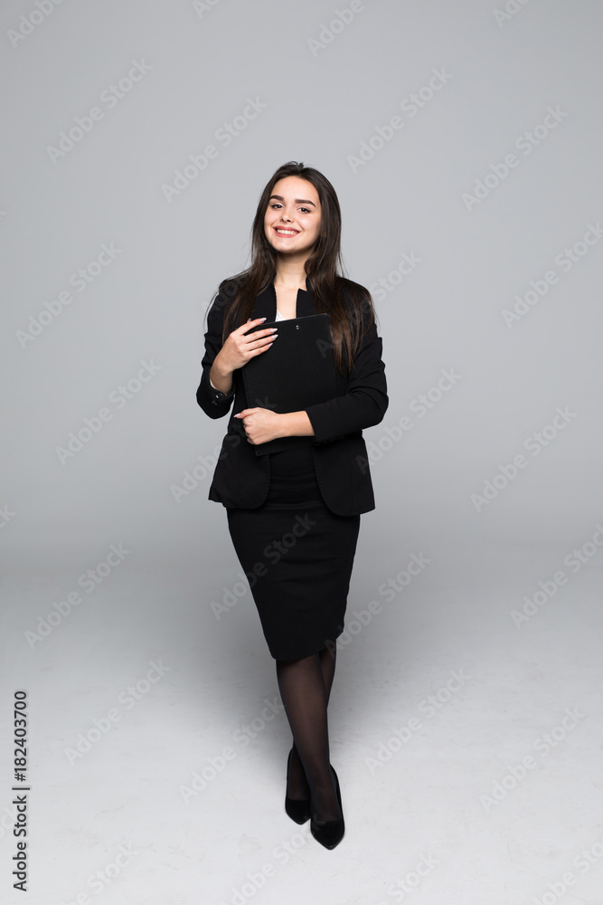 Full body portrait of professional business woman with blanck standing on gray background Full body portrait of professional business woman with blanck standing on gray background