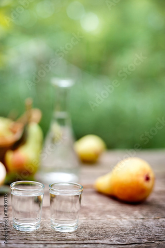 Shot glass and pear in the background