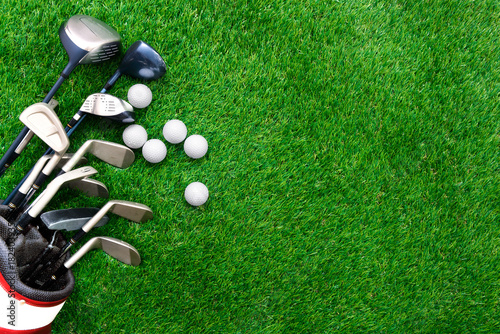 Golf ball and golf club in bag on green grass photo
