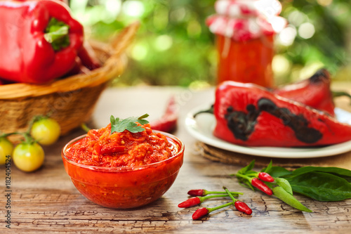 Traditional ajvar in bowl with chili peppers