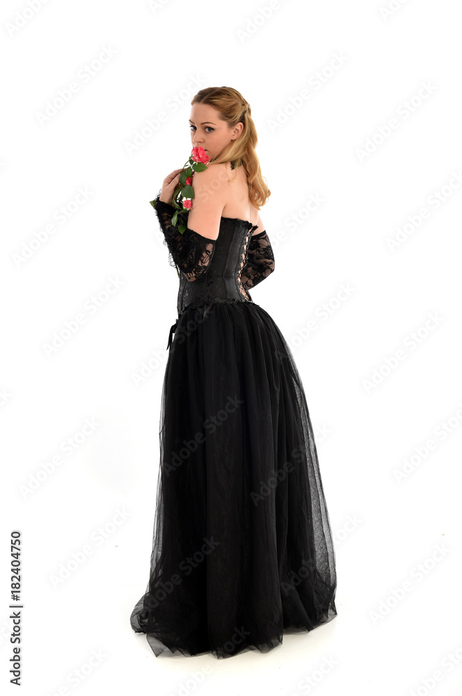 full length portrait of a blonde girl wearing black gothic gown. standing pose, isolated on white background. full length portrait of a blonde girl wearing black gothic gown. standing pose, isolated on white background.