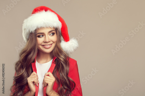 Portrait of cute smiling woman in santa hat. Christmas.