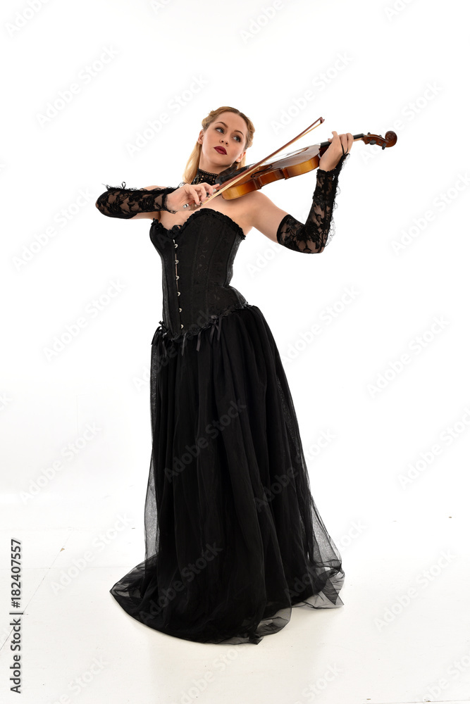 full length portrait of a blonde girl wearing black gothic gown. standing pose, isolated on white background. full length portrait of a blonde girl wearing black gothic gown. standing pose, isolated on white background.