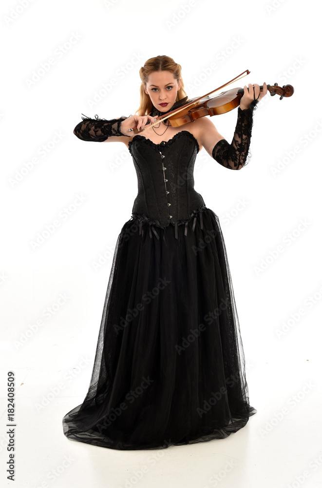 full length portrait of a blonde girl wearing black gothic gown. standing pose, isolated on white background. full length portrait of a blonde girl wearing black gothic gown. standing pose, isolated on white background.