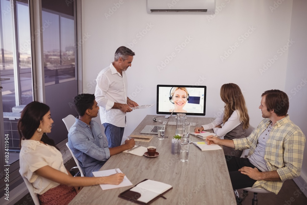 Business people looking at screen during video conference in