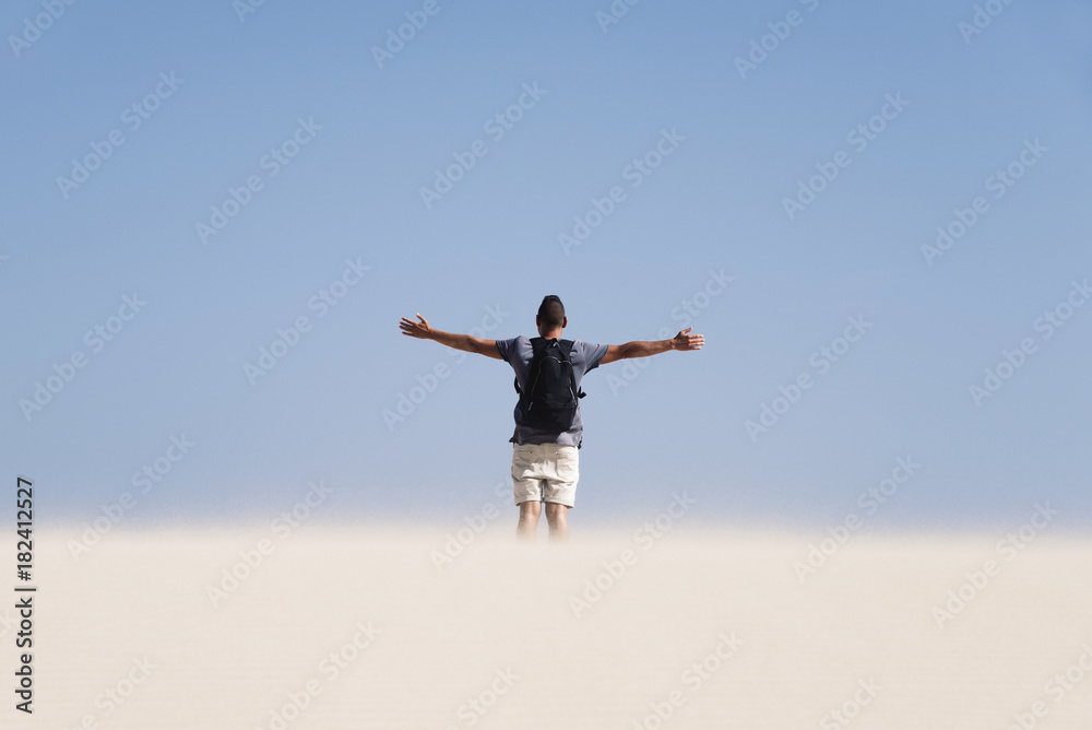 young man with a backpack in the desert young man with a backpack in the desert